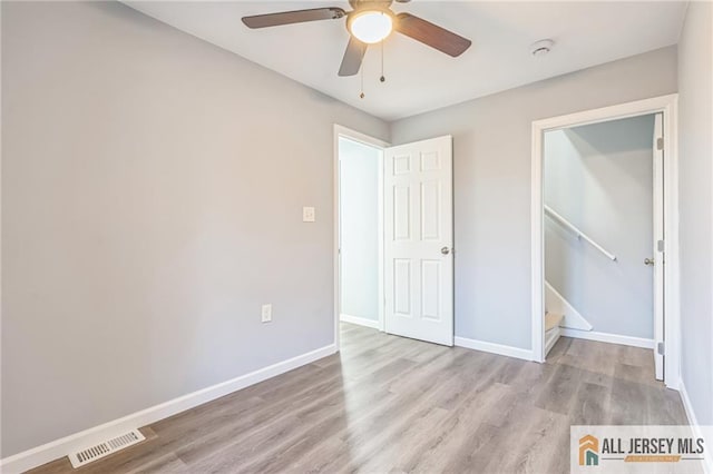 unfurnished bedroom with ceiling fan, light hardwood / wood-style floors, and a closet