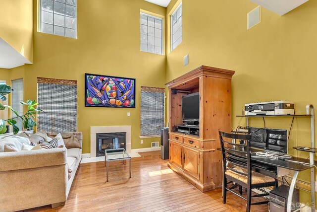 office area with a high ceiling and light hardwood / wood-style floors