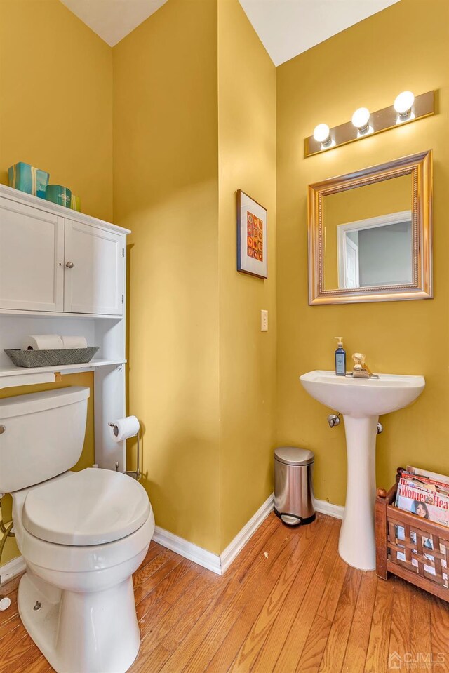 bathroom featuring toilet and wood-type flooring