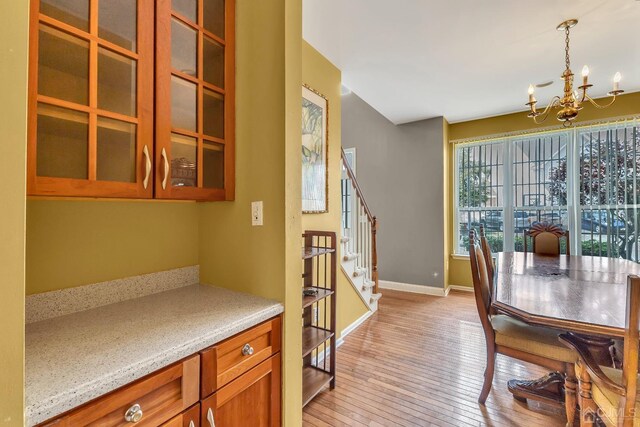 dining room with light wood-type flooring and an inviting chandelier