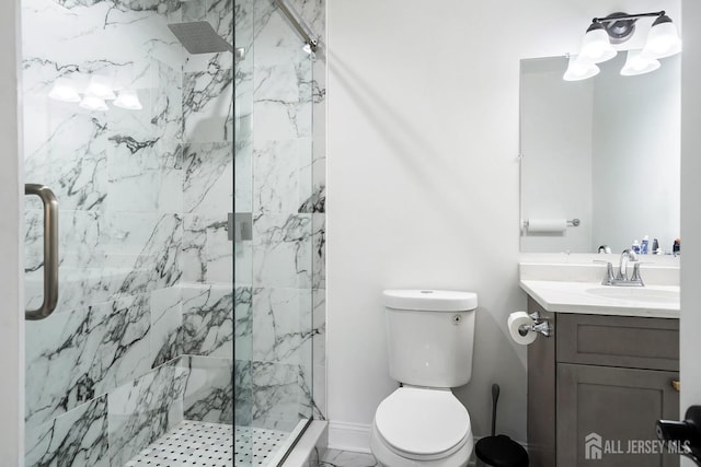 bathroom with a shower with door, vanity, and toilet