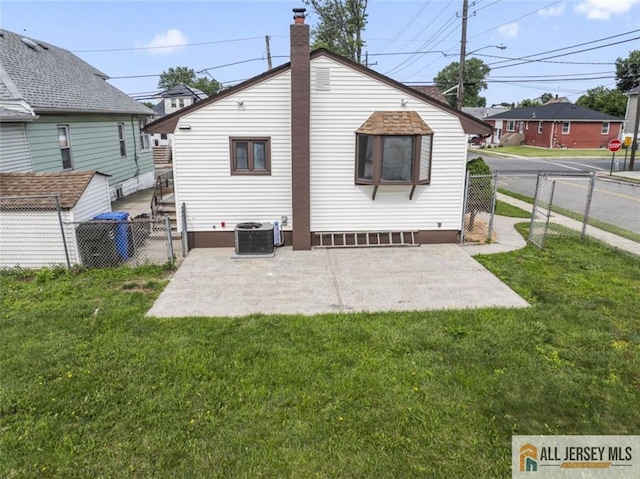 114 Holly St, Port Reading, NJ 07064 - back of property featuring a fenced backyard, a patio area, and a chimney