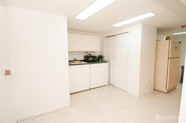 5 Dan Ct, Old Bridge, NJ 08857 - kitchen with freestanding refrigerator, white cabinetry, black microwave, and dark countertops