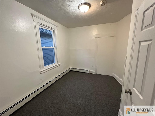 427 John St, Plainfield, NJ 07060 - spare room with a smoke detector, baseboard heating, a textured ceiling, dark carpet, and baseboards