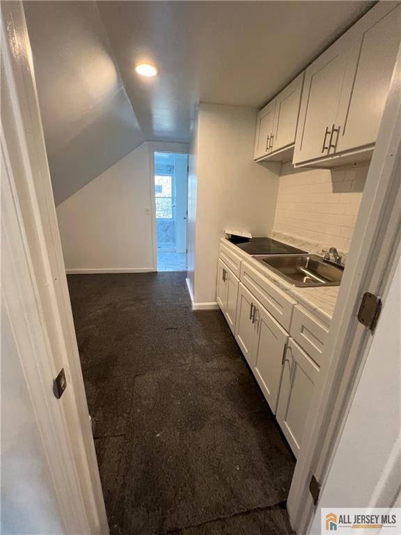 427 John St, Plainfield, NJ 07060 - kitchen with a sink, white cabinets, lofted ceiling, backsplash, and baseboards