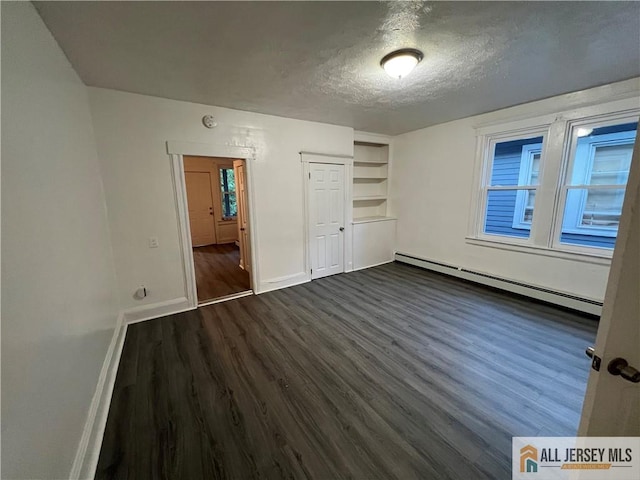 427 John St, Plainfield, NJ 07060 - unfurnished bedroom with baseboard heating, dark wood-style flooring, baseboards, a textured ceiling, and a closet