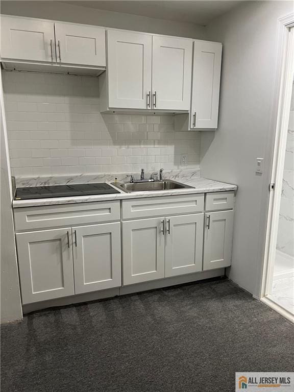 427 John St, Plainfield, NJ 07060 - kitchen with a sink, light countertops, white cabinets, black electric cooktop, and dark colored carpet