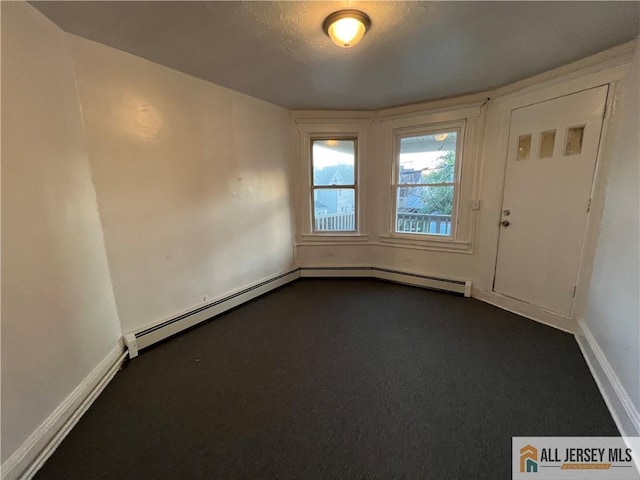 427 John St, Plainfield, NJ 07060 - empty room featuring dark colored carpet, baseboard heating, and baseboards