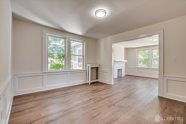 160 Academy St, South Orange Village, NJ 07079 - unfurnished living room with a decorative wall, wood finished floors, a fireplace, and wainscoting