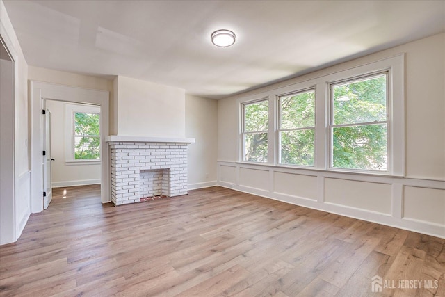 160 Academy St, South Orange Village, NJ 07079 - unfurnished living room with healthy amount of natural light, light wood finished floors, a fireplace, and a decorative wall