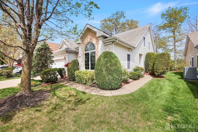 27 Dawson Ln, Monroe, NJ 08831 - view of side of home featuring an attached garage, central air condition unit, a shingled roof, and a lawn