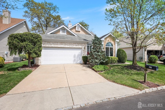 27 Dawson Ln, Monroe, NJ 08831 - view of front of property with stone siding, an attached garage, a front lawn, driveway, and roof with shingles