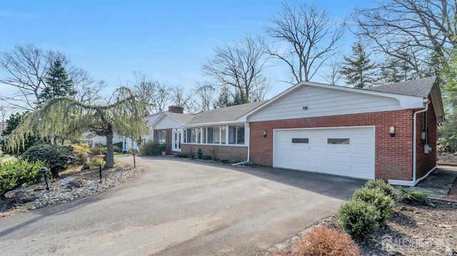 single story home with an attached garage, driveway, and brick siding