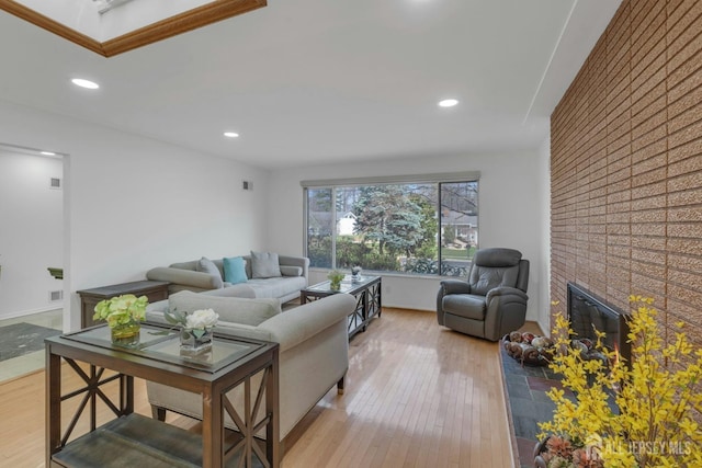 living room with recessed lighting, wood finished floors, and a fireplace
