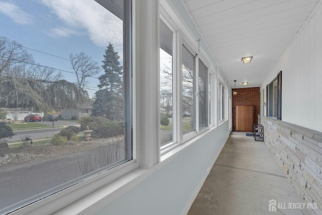hallway with brick wall and concrete flooring