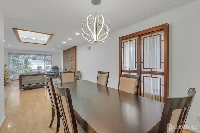dining area with light wood-style flooring, recessed lighting, and an inviting chandelier