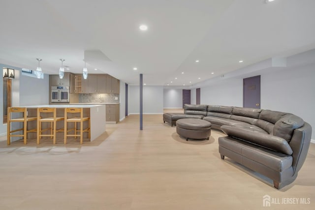 living room featuring light wood-style floors, baseboards, and recessed lighting