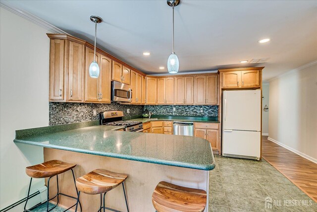 16 Rachele Ct, Old Bridge, NJ 07747 - kitchen with appliances with stainless steel finishes, a baseboard heating unit, crown molding, a peninsula, and decorative backsplash