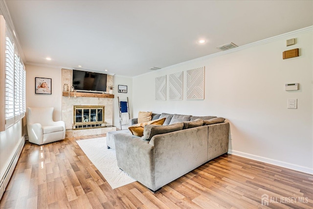 16 Rachele Ct, Old Bridge, NJ 07747 - living room featuring baseboard heating, ornamental molding, light wood-type flooring, a large fireplace, and baseboards