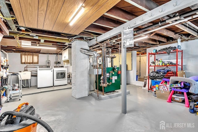 below grade area featuring a sink, separate washer and dryer, and a heating unit