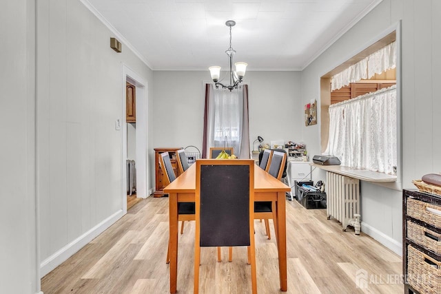 dining space featuring a notable chandelier, radiator heating unit, light wood finished floors, and ornamental molding