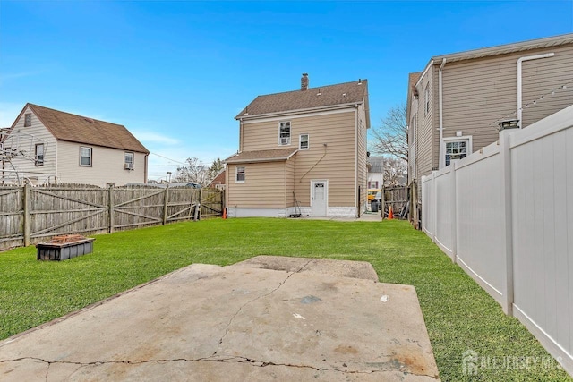 back of property featuring a yard, a patio area, and a fenced backyard