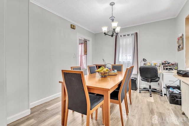 dining space featuring crown molding, light wood-style flooring, baseboards, and a chandelier