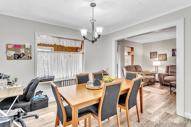 dining area featuring an inviting chandelier, a healthy amount of sunlight, light wood-type flooring, and ornamental molding