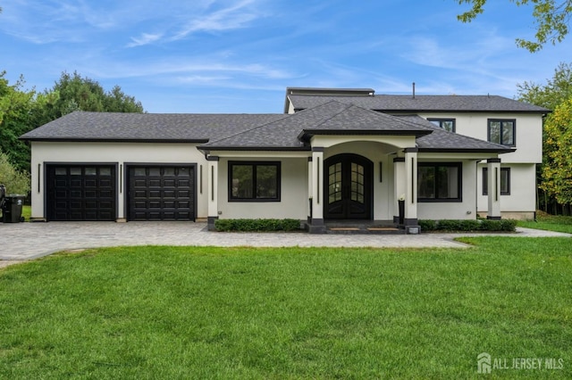 view of front facade featuring a garage, a front yard, and french doors