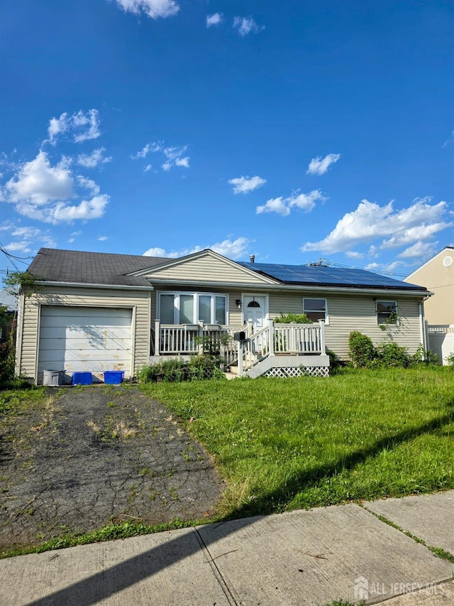 41 Harrison Ave, Carteret, NJ 07008 - ranch-style house featuring an attached garage, roof mounted solar panels, and asphalt driveway