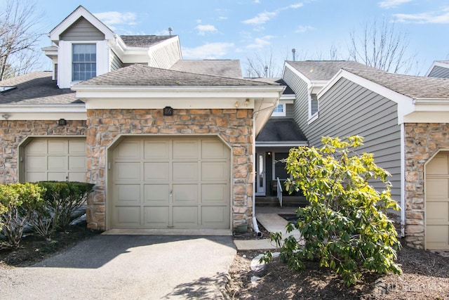 view of front of property with a garage, driveway, and a shingled roof