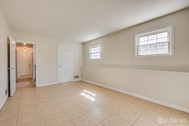 unfurnished bedroom featuring light tile patterned floors, visible vents, and baseboards