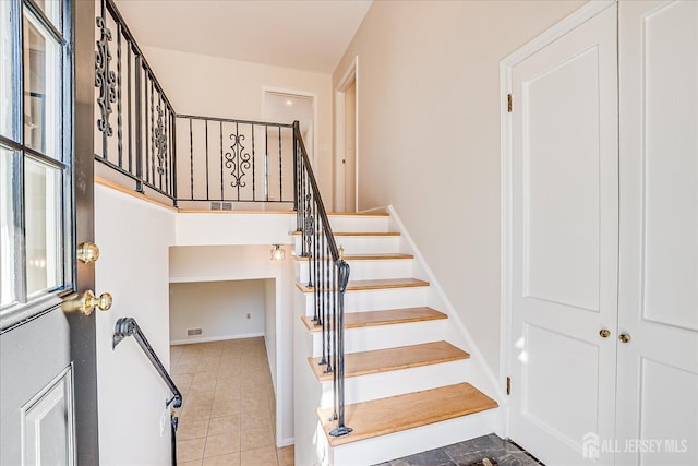 stairway featuring baseboards and tile patterned flooring