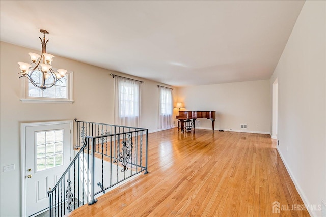 interior space featuring a chandelier, light wood-style flooring, and plenty of natural light