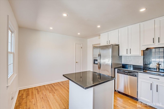 kitchen featuring dark countertops, stainless steel appliances, and light wood-type flooring