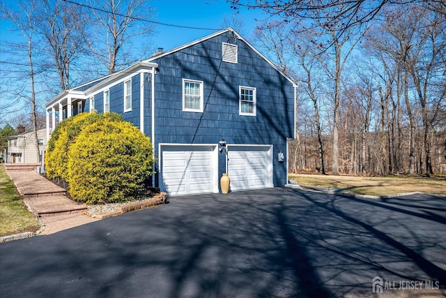 view of home's exterior with a garage and driveway