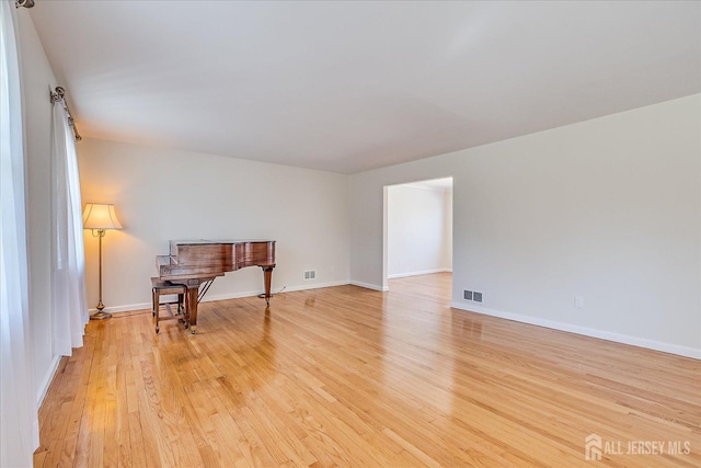 interior space featuring baseboards, visible vents, and light wood-style floors