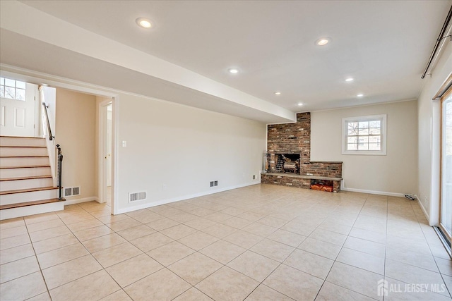 unfurnished living room with a brick fireplace, light tile patterned floors, visible vents, and recessed lighting