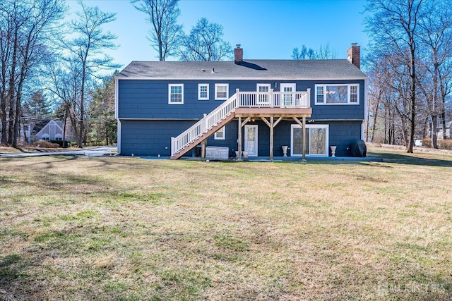 view of front facade with a chimney, stairs, a wooden deck, and a front lawn