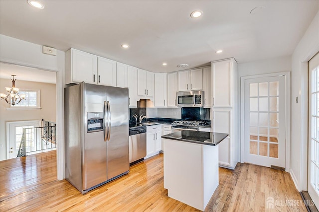 kitchen featuring white cabinetry, a notable chandelier, stainless steel appliances, and a sink