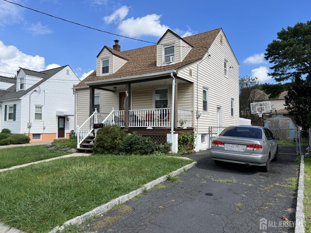 22 State St, Carteret, NJ 07008 - cape cod home with a porch, a shingled roof, a chimney, a front yard, and cooling unit