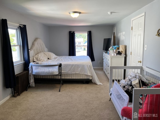 bedroom featuring light carpet and radiator heating unit