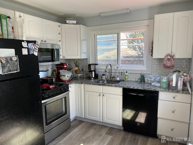 kitchen with black appliances, white cabinets, light wood-type flooring, and sink