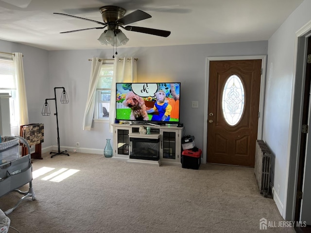 22 State St, Carteret, NJ 07008 - carpeted living room with radiator heating unit, ceiling fan, baseboards, and a glass covered fireplace