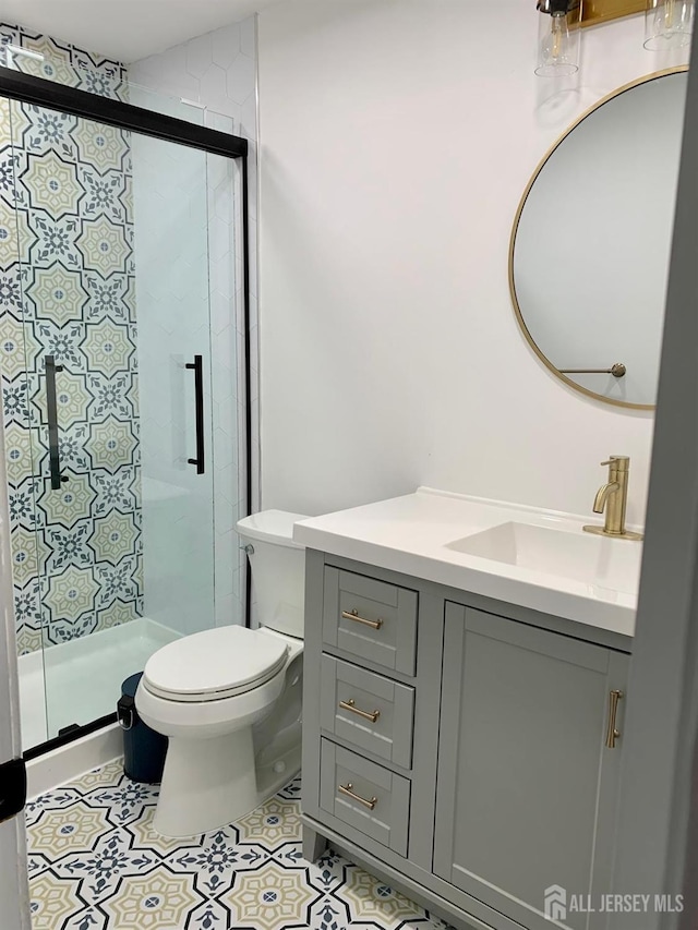 full bath with vanity, tile patterned floors, toilet, and a stall shower