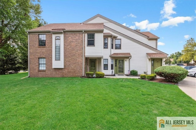 view of front of property featuring brick siding and a front lawn