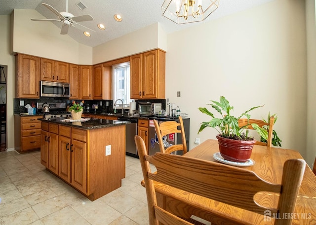 136 Chichester Rd, Monroe, NJ 08831 - kitchen with stainless steel appliances, a center island, brown cabinetry, lofted ceiling, and ceiling fan