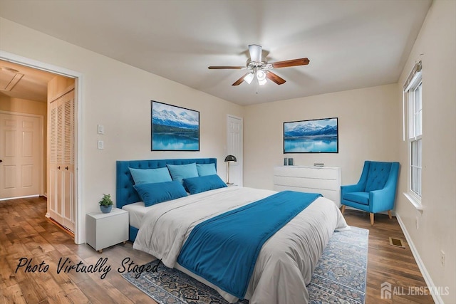 bedroom featuring visible vents, attic access, a ceiling fan, wood finished floors, and baseboards