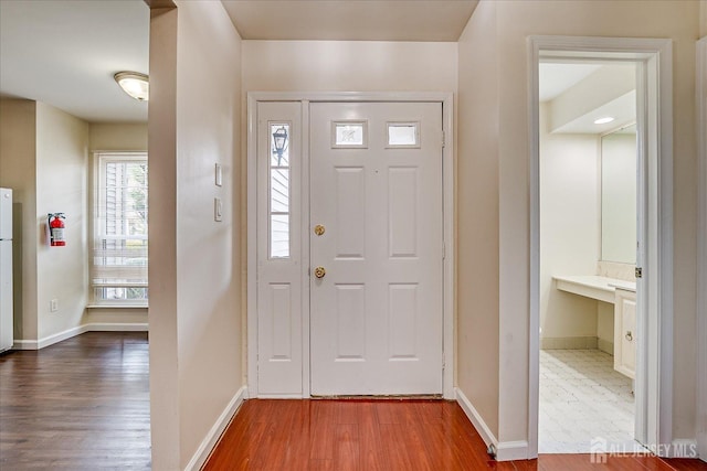 foyer featuring wood finished floors and baseboards