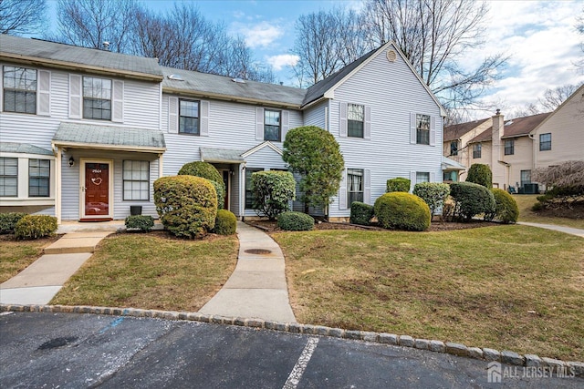 townhome / multi-family property with uncovered parking, central AC unit, and a front yard